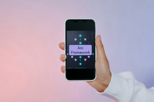 A hand holding a smartphone that displays the 'Arc Framework' logo on its screen, set against a soft pink and purple gradient background.